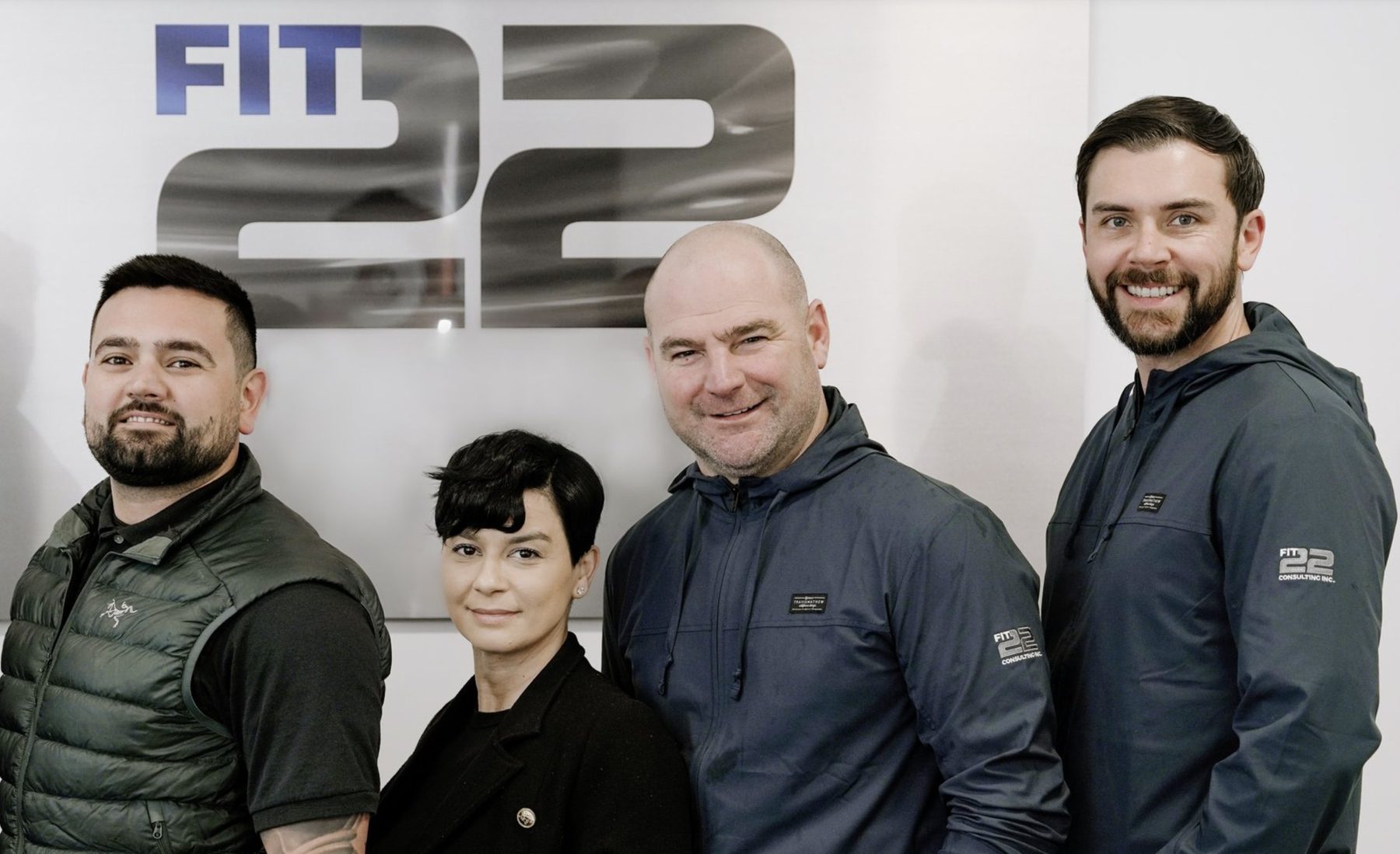 The Fit22 team in front of the Fit22 sign at the Surrey warehouse and sales office